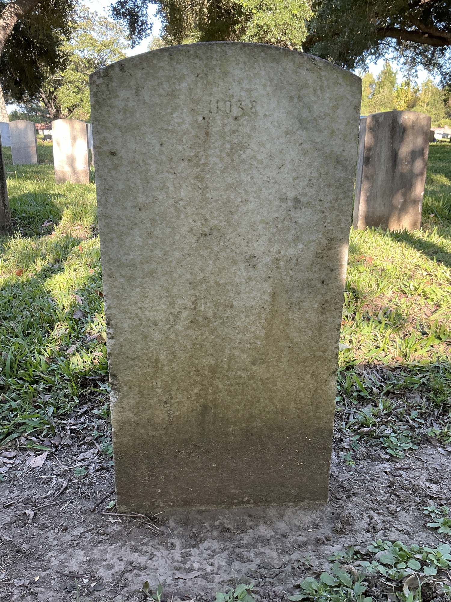 Back of upright marble headstone with flat face.