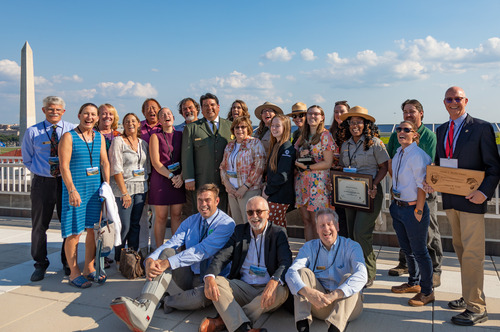 Award recipients pose with NPS Director Sams following the ceremony with the Washington Monument and DC skyline in the background. 