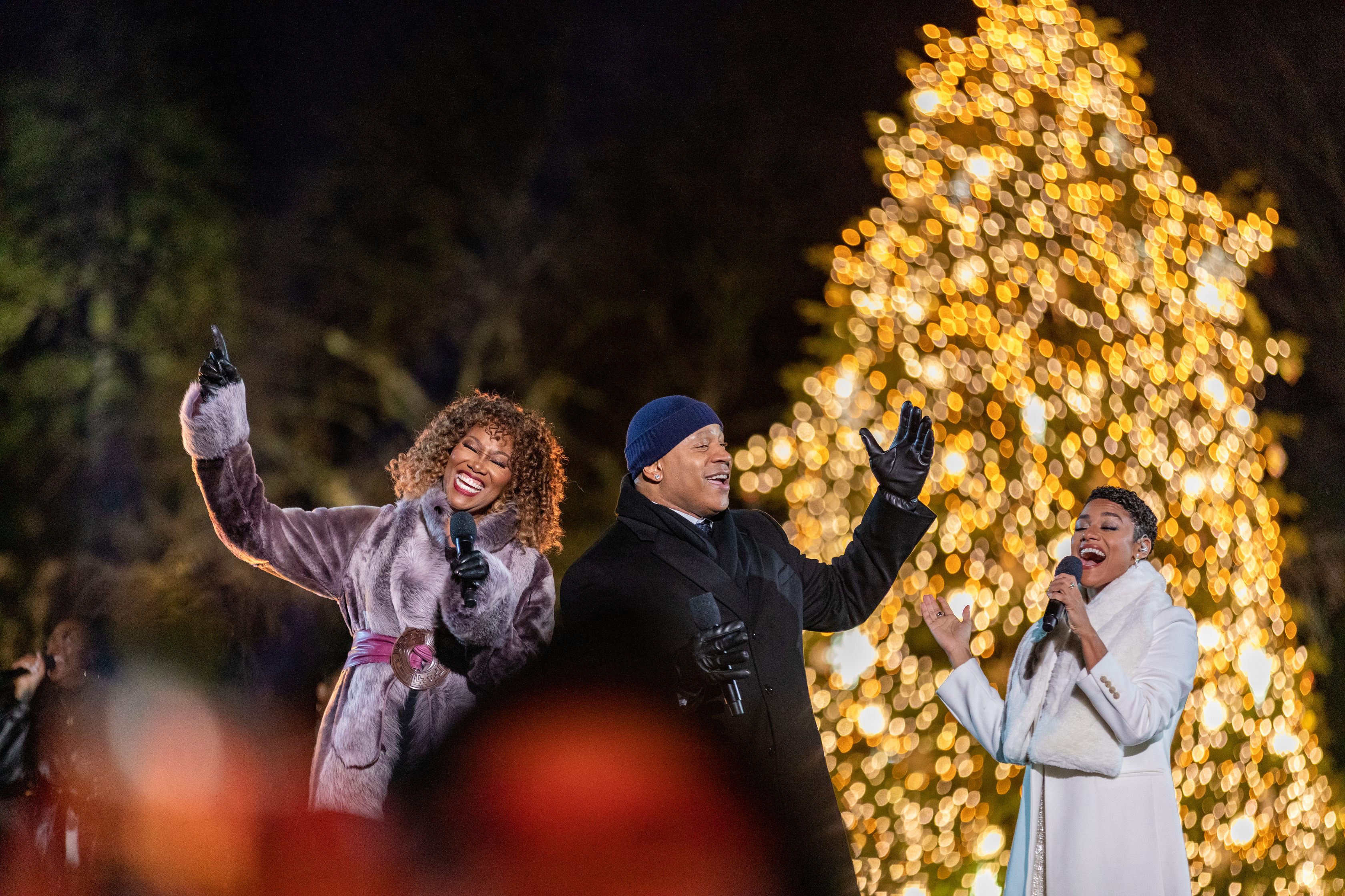 Yolanda Adams, LL Cool J and Ariana DeBose raise their arms up and sing