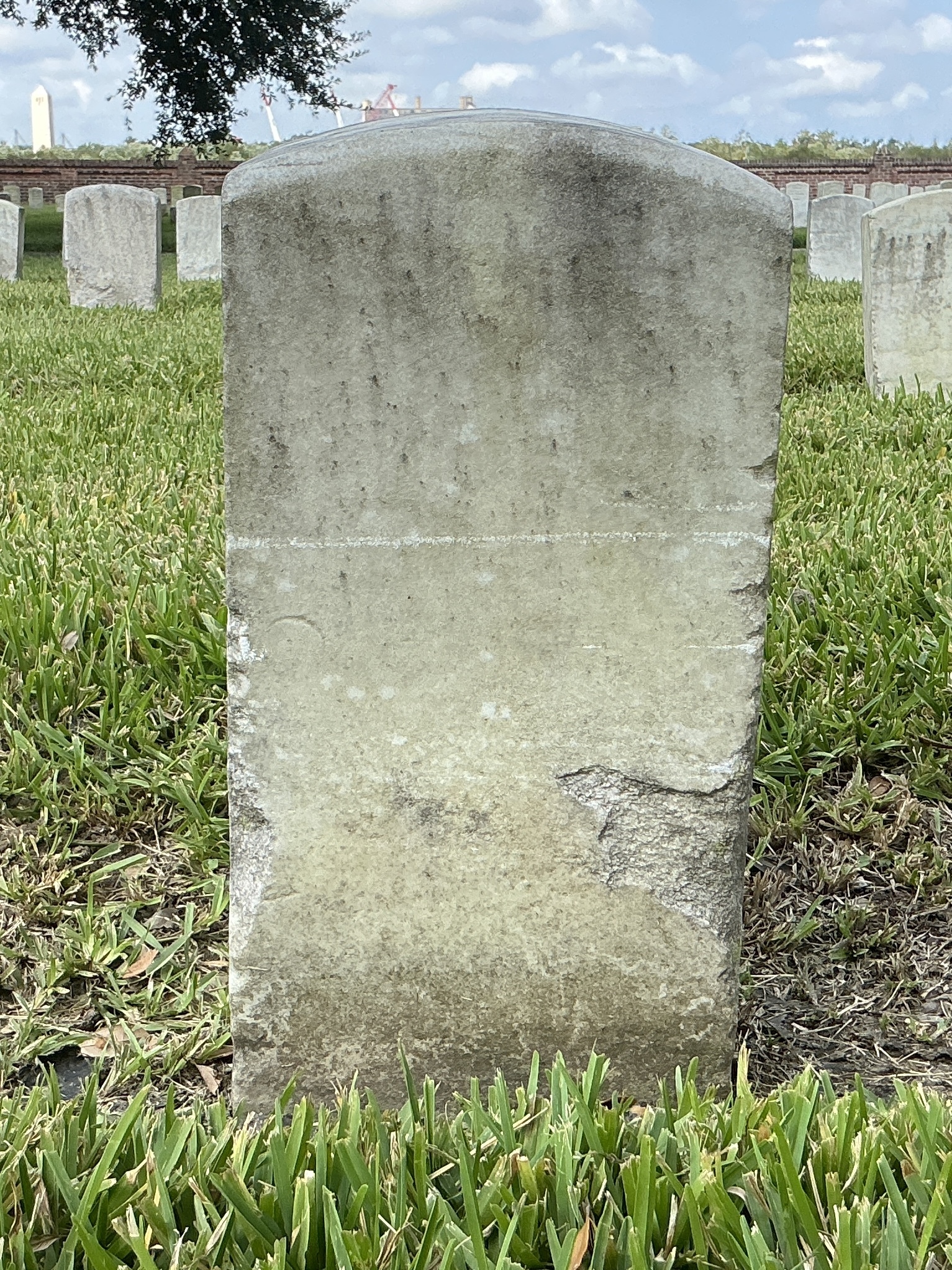 Back of historic upright marble headstone with recessed shield with recessed lettering face.