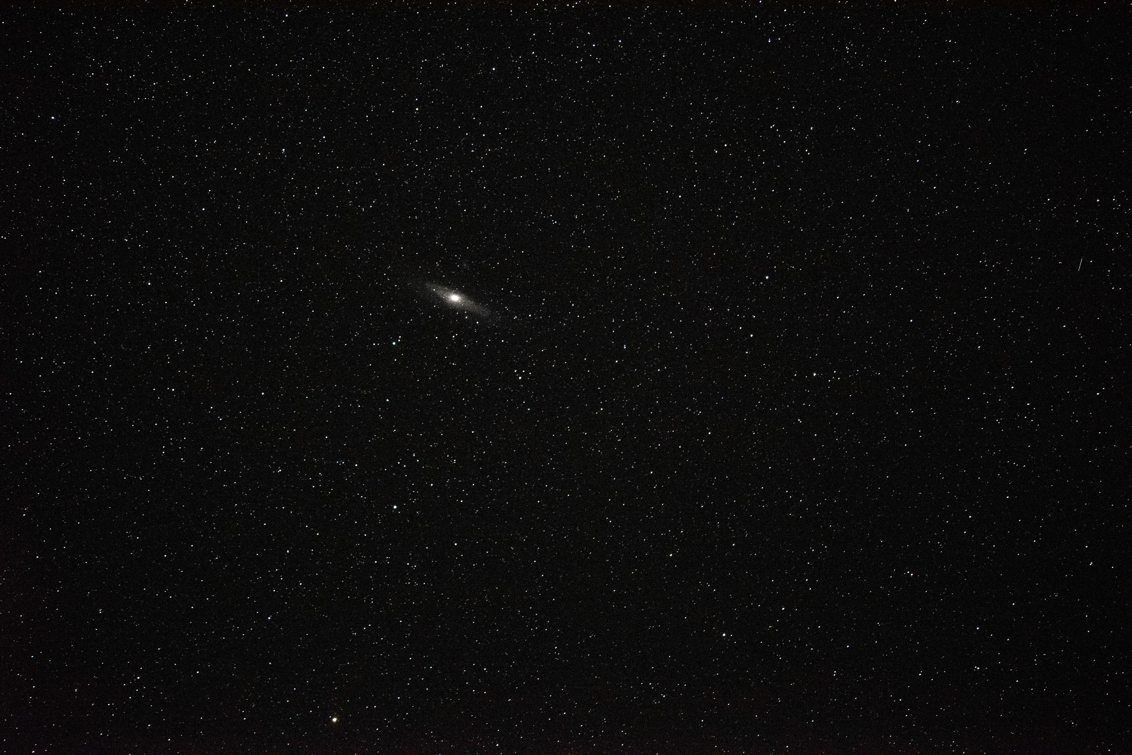 A bright disk shape glows in a black star filled sky.