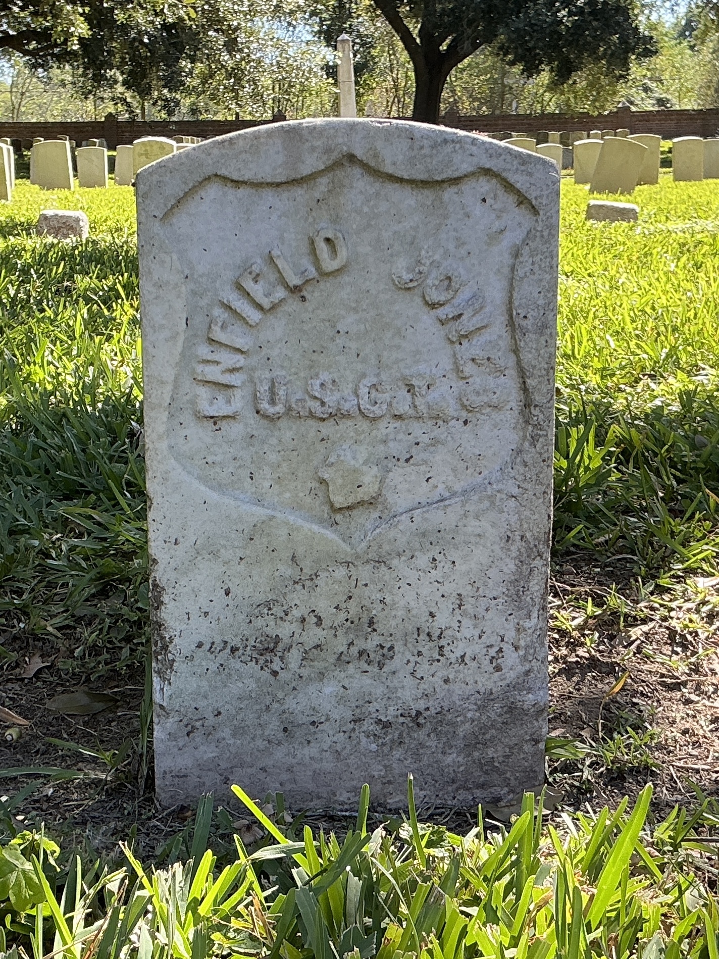 Back of historic upright marble headstone with recessed shield face.