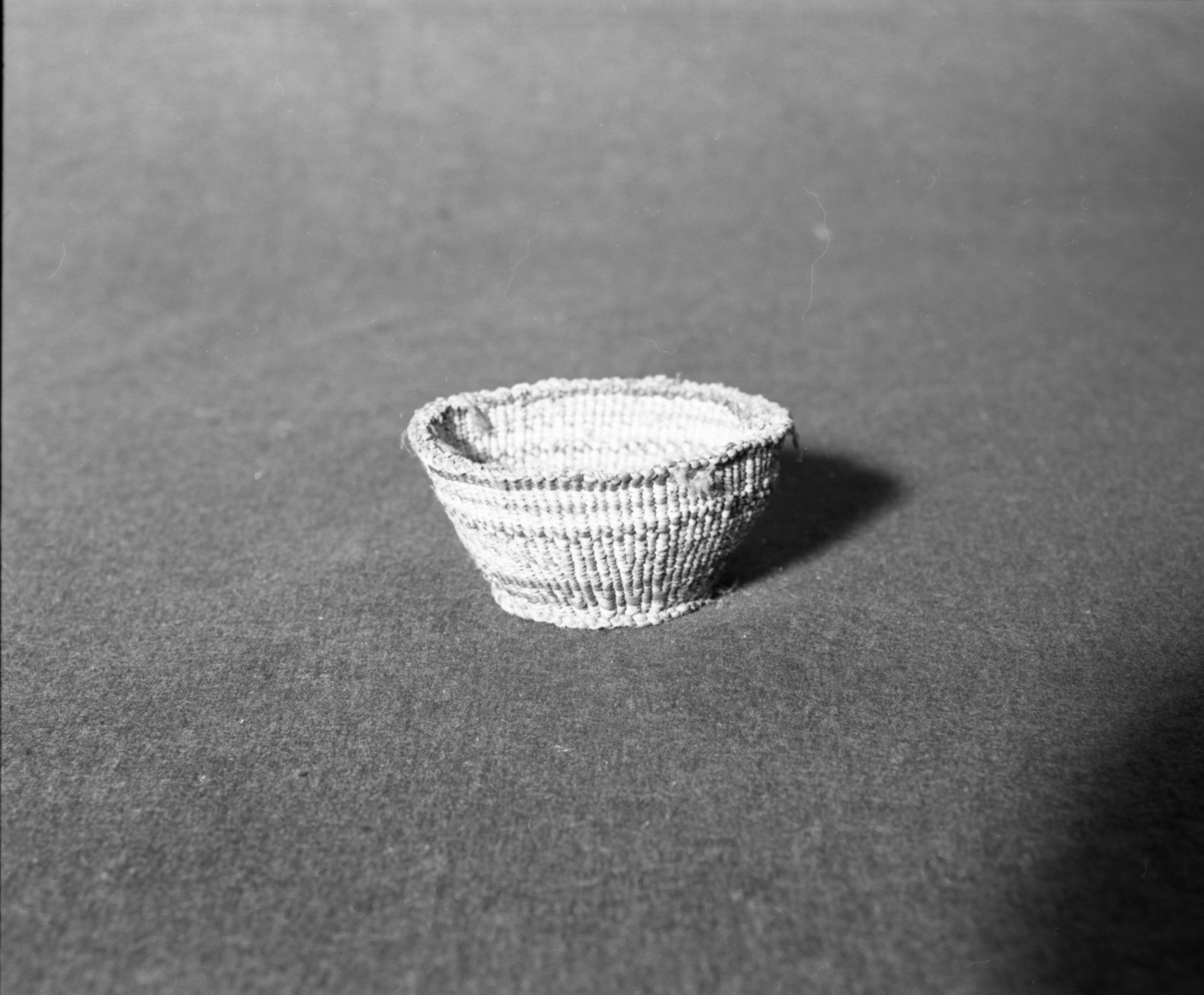 Marie Rozier Collection, Catalog No. 85. Object: Klamath/Modoc basket. Dimensions: 3 1/2" diameter x 2" height. Materials: tule stalk sheath. Technology: down to right slant of turns; tule cordage warps. Collection History: Gift of G. DuGay. Photographed by Michael Dixon, December 1982. Catalogued by Craig Bates and Barbara Beroza. Yosemite Collections, National Park Service.