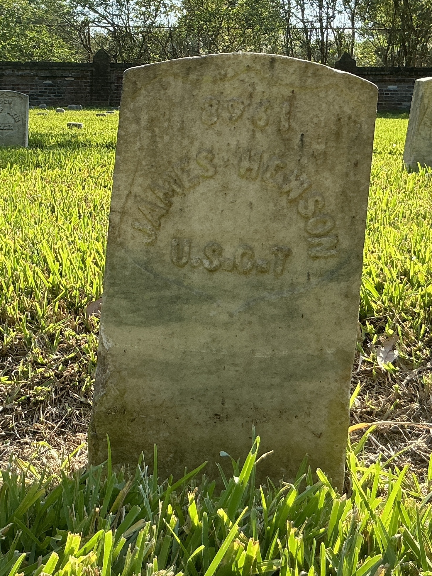 Front of historic upright marble headstone with recessed shield face.