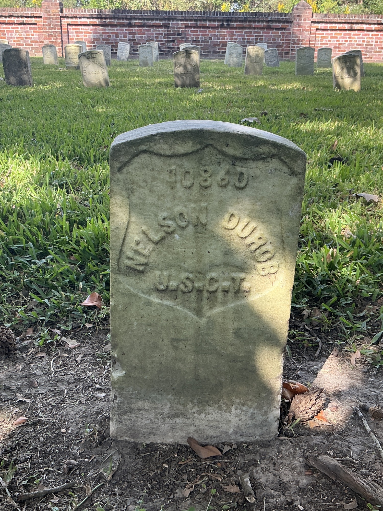 Front of historic upright marble headstone with recessed shield face.