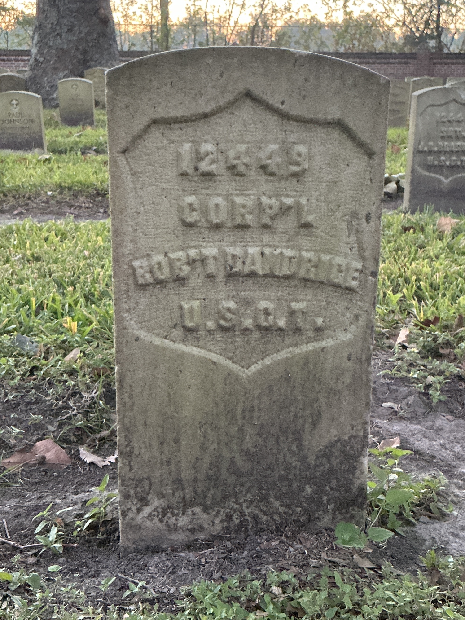 Front of historic upright marble headstone with recessed shield face.