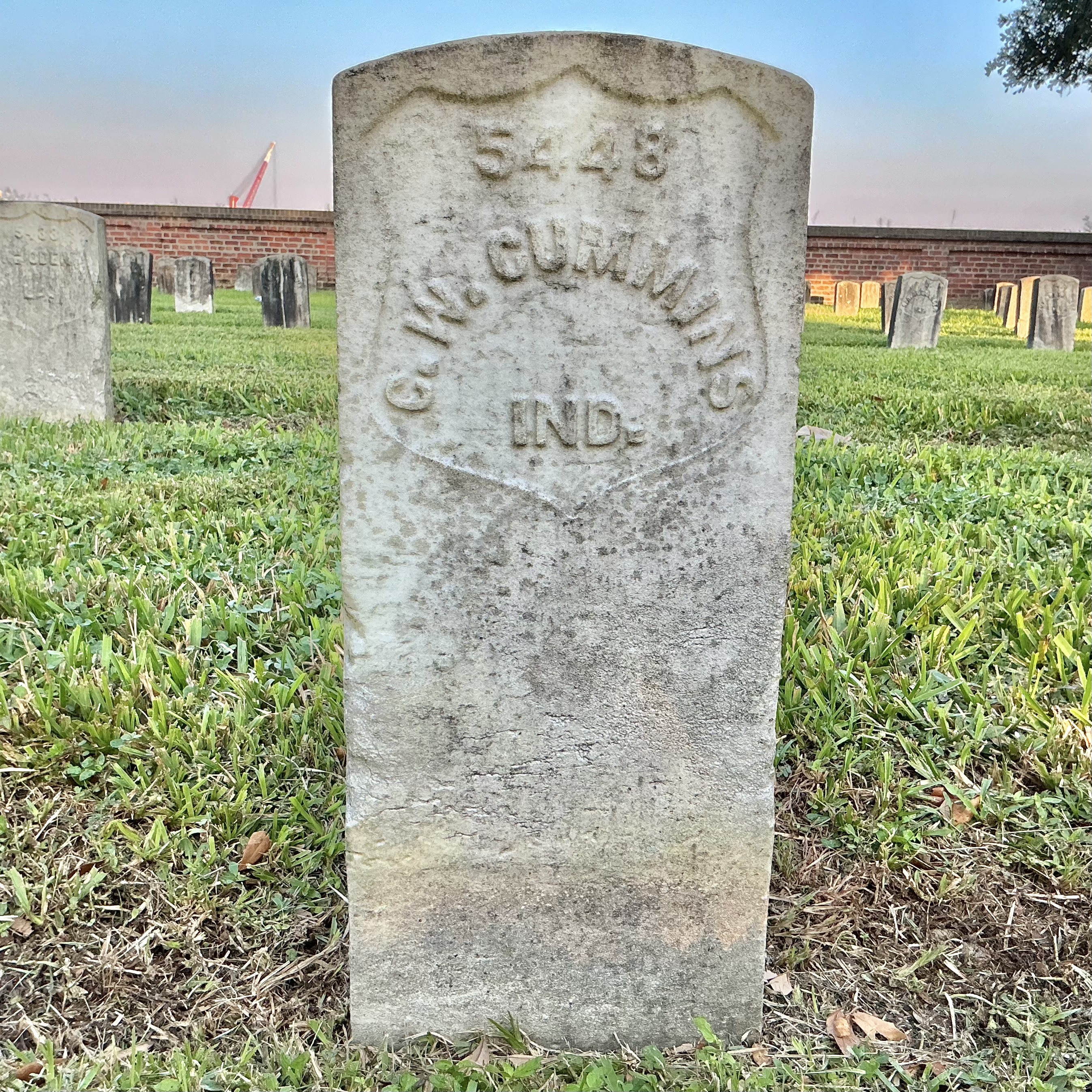 Front of historic upright marble headstone with recessed shield face.