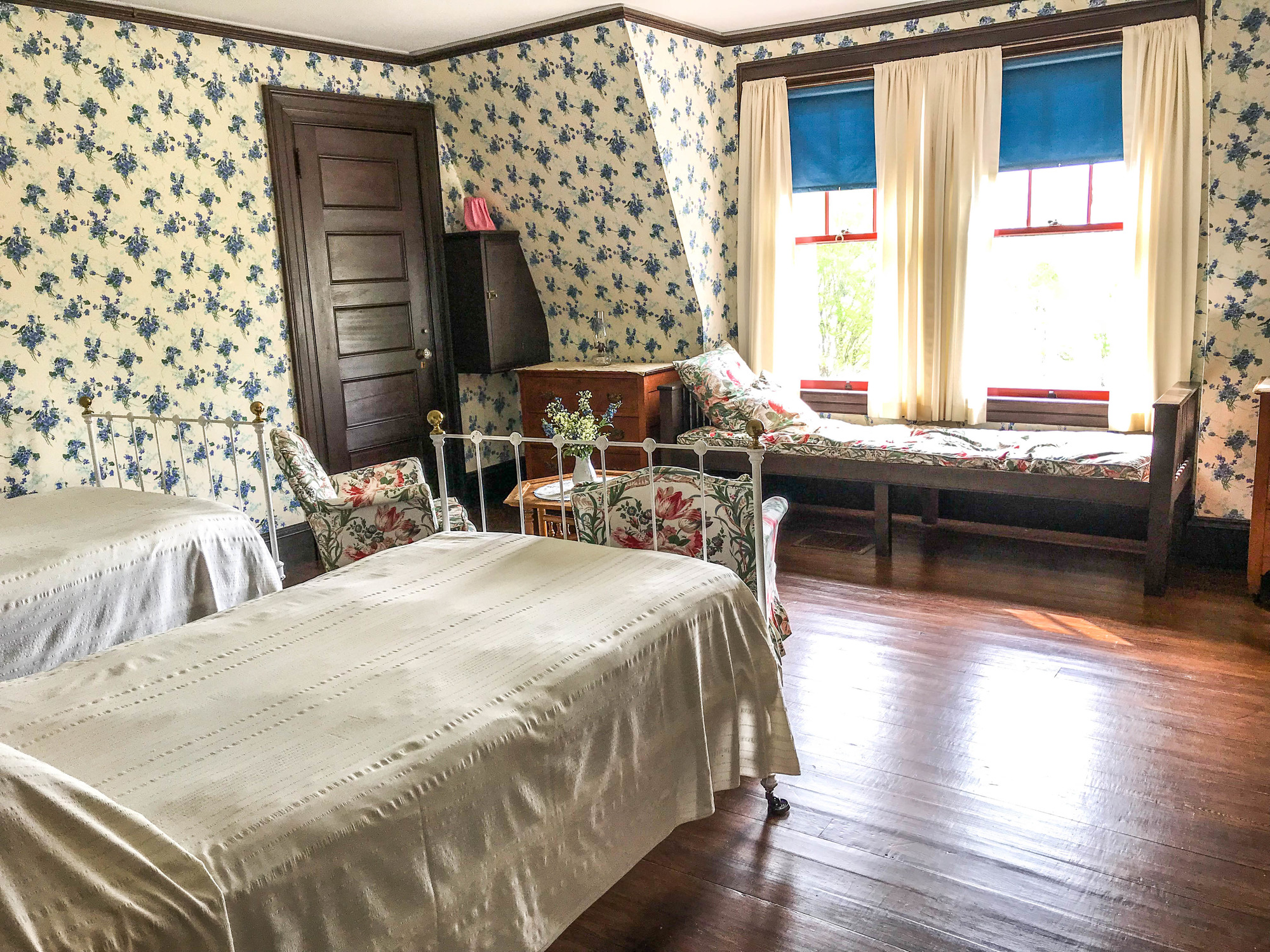 Bedroom with two beds, a day bed, and small table