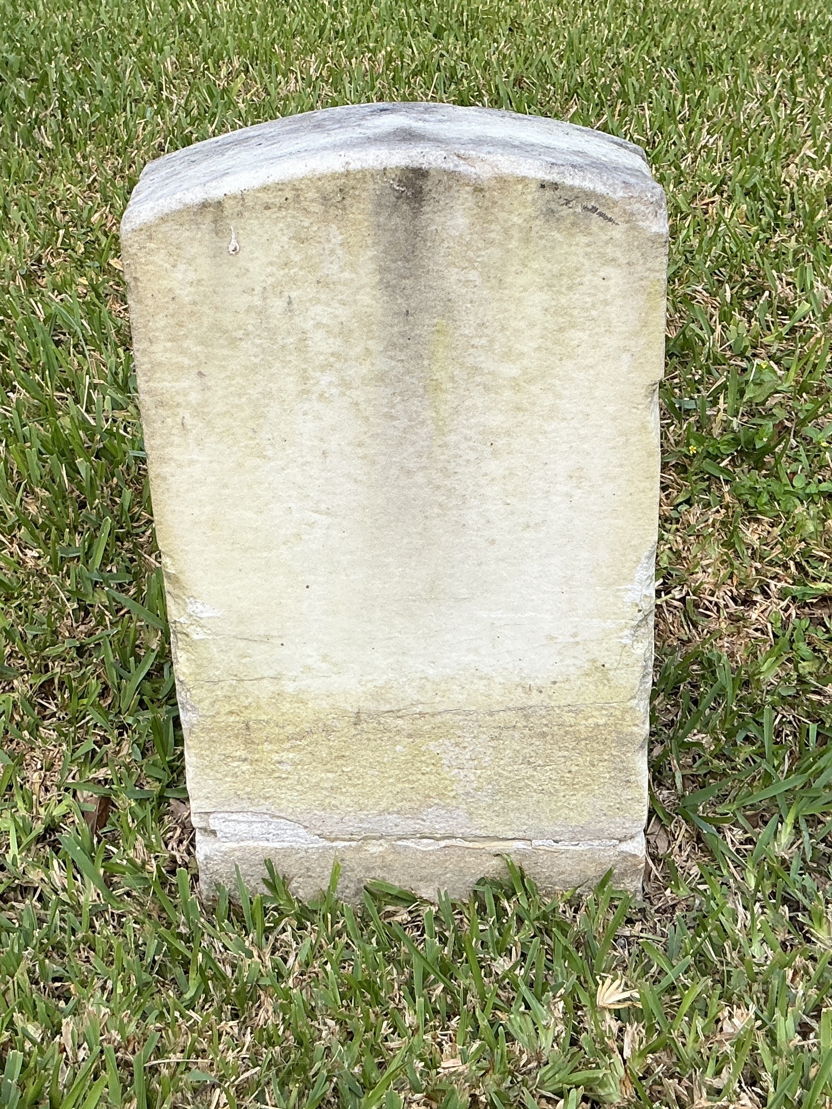 Back of historic upright marble headstone with recessed shield face.