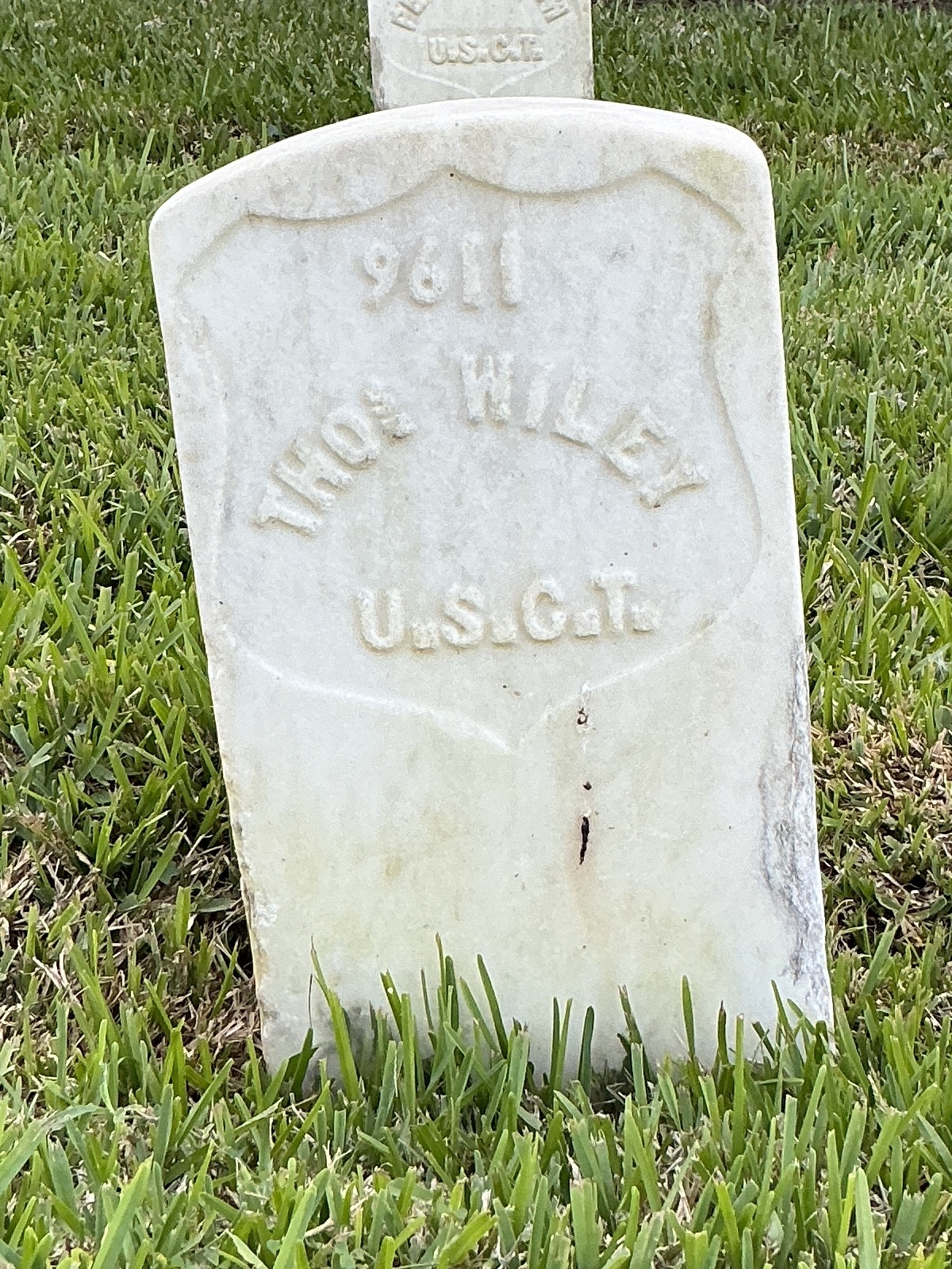 Front of historic upright marble headstone with recessed shield face.