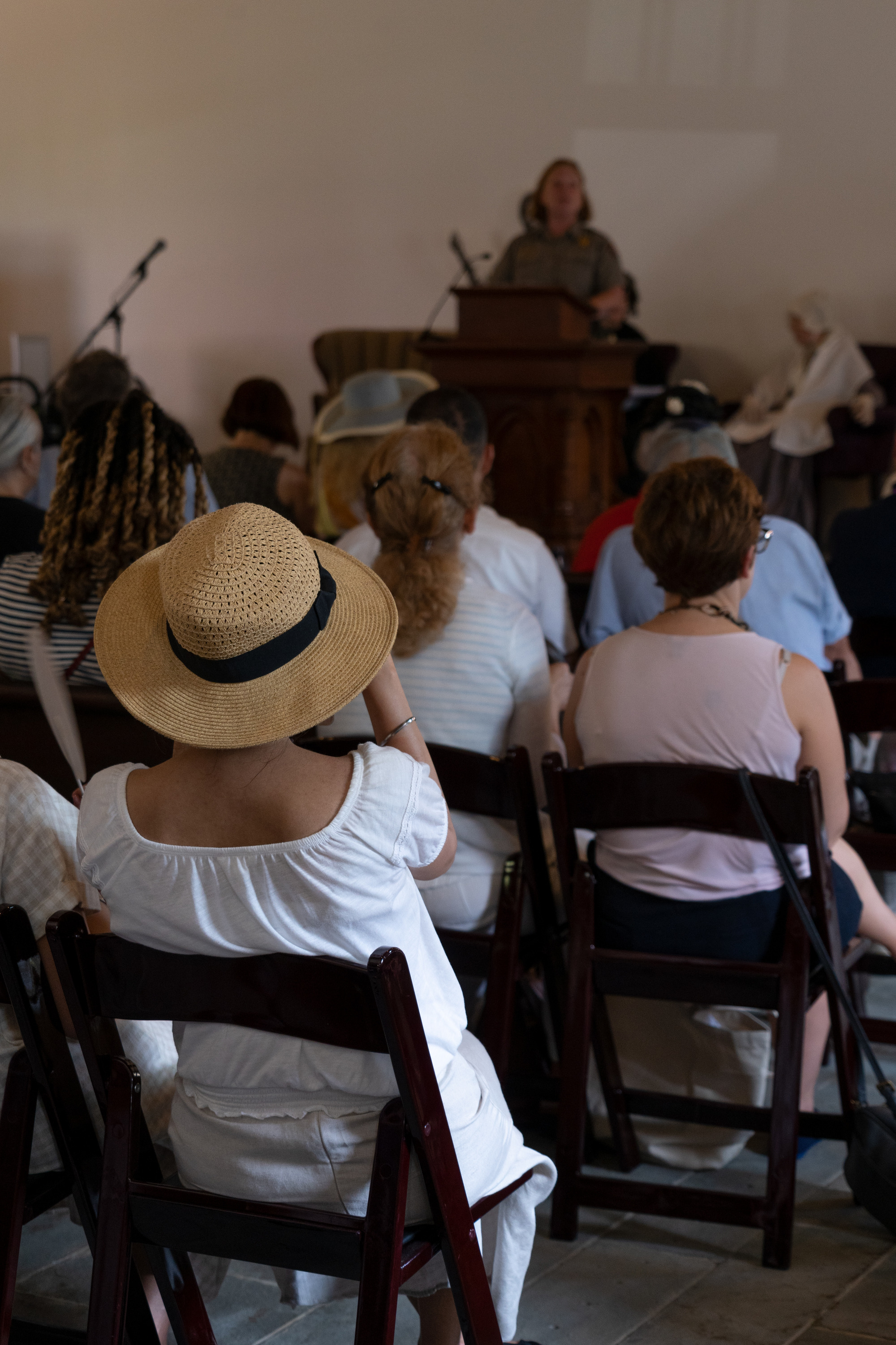 A Park Ranger speaks to an audience in a historical chapel.