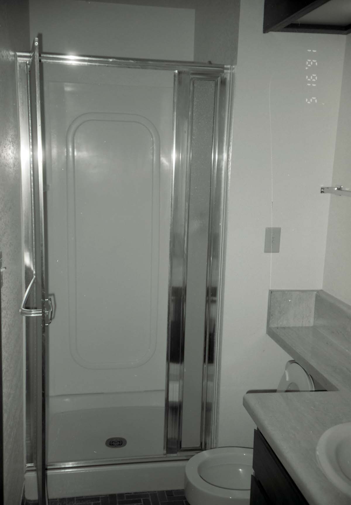 Shower in bathroom of barracks. [Image possibly for comparative housing study]