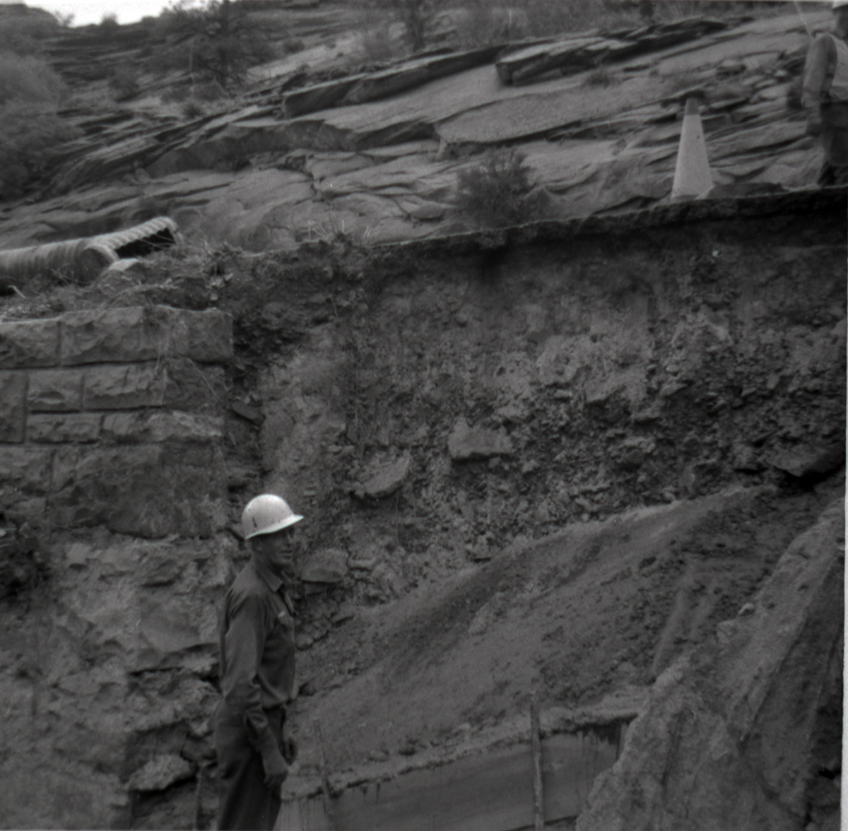 Man working on retaining wall repairs along East Rim road.