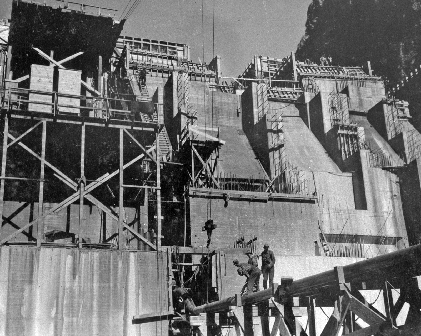 Men working in front of large dam