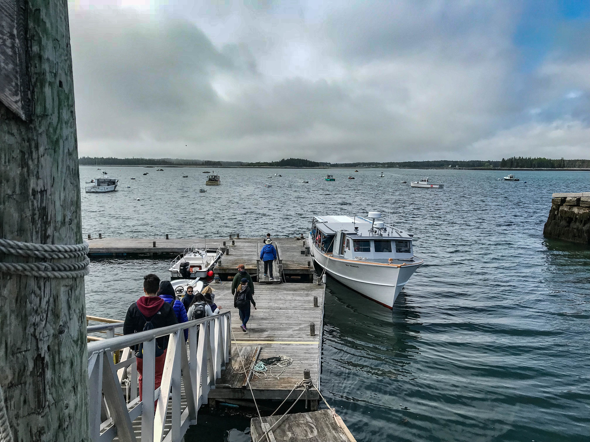 People walking down a ramp to a docked boat