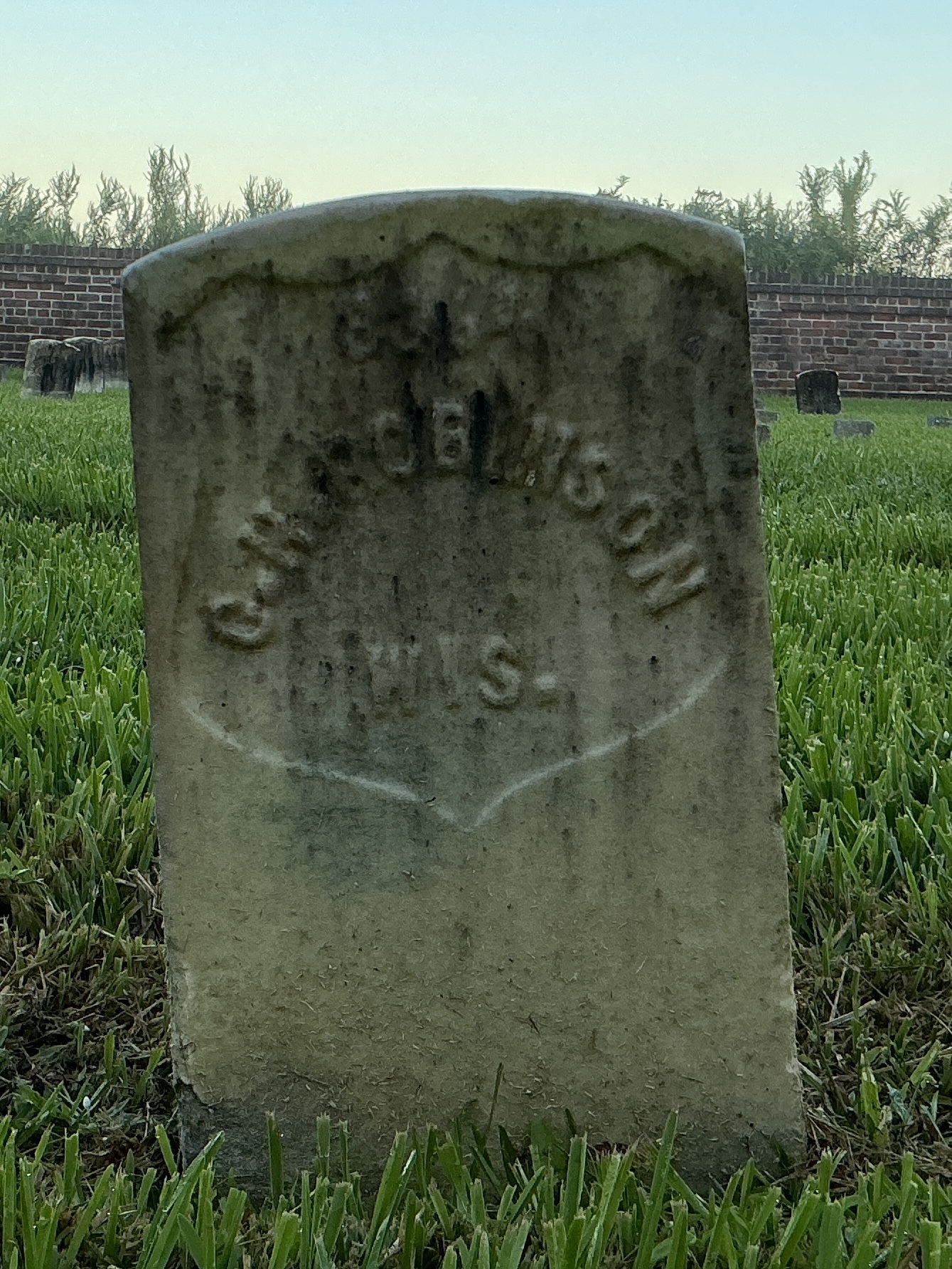 Front of historic upright marble headstone with recessed shield face.
