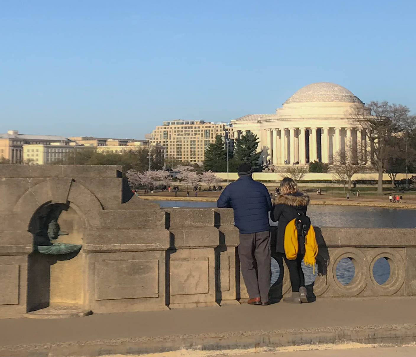 Visitors standing on a bridge looking at the Thomas Jefferson Memorial across the Tidal Basin