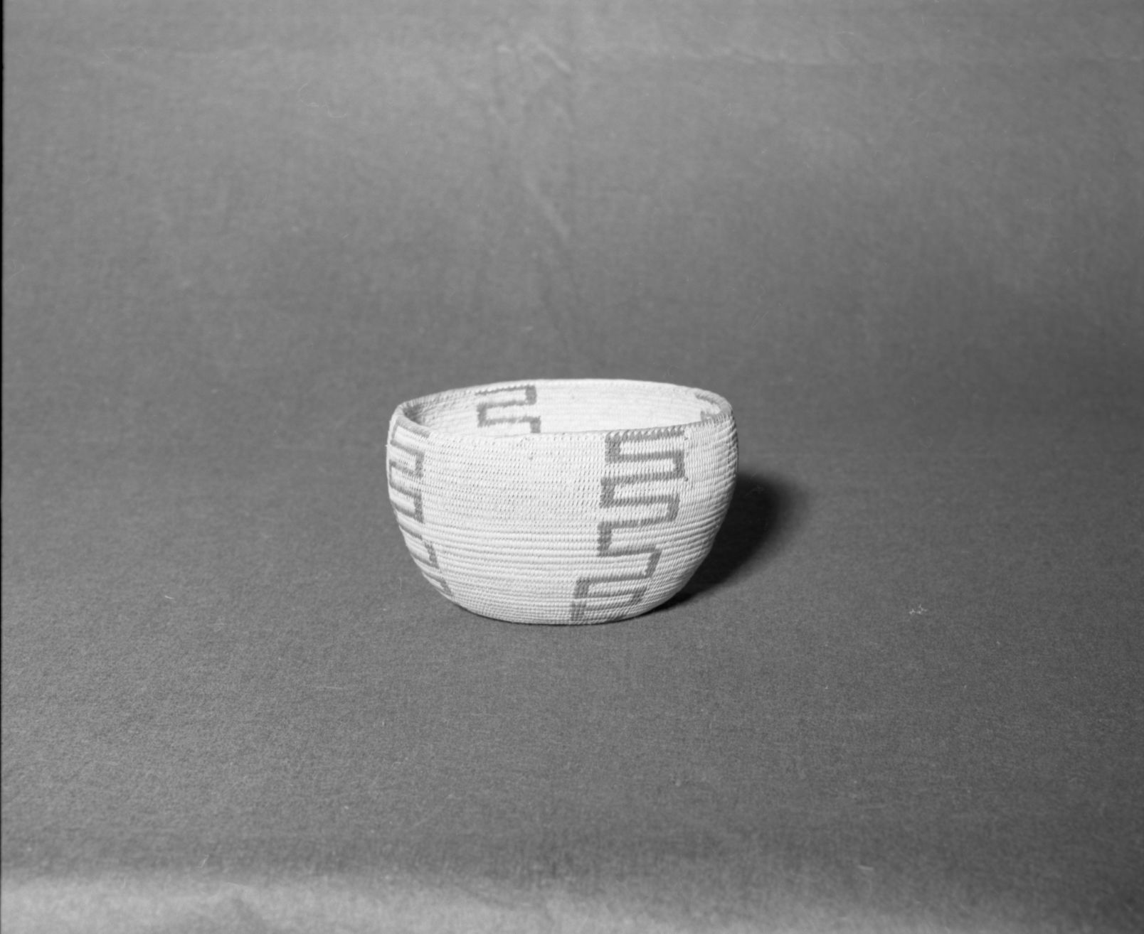 Mrs. Donald Segerstrom Collection. Object: Paiute basket. Dimensions: 6 3/4 x 4". Materials: split willow, bracken fern root. Technology: split single rod construction, non-interlocking stitch, fag ends trimmed on work face, moving ends trimmed on interior, overstitched rim, leftward coil direction. Collection History: ---. Photographed by Michael Dixon, 1/83. Catalogued by Craig Bates and Barbara Beroza. Yosemite Collections, National Park Service.