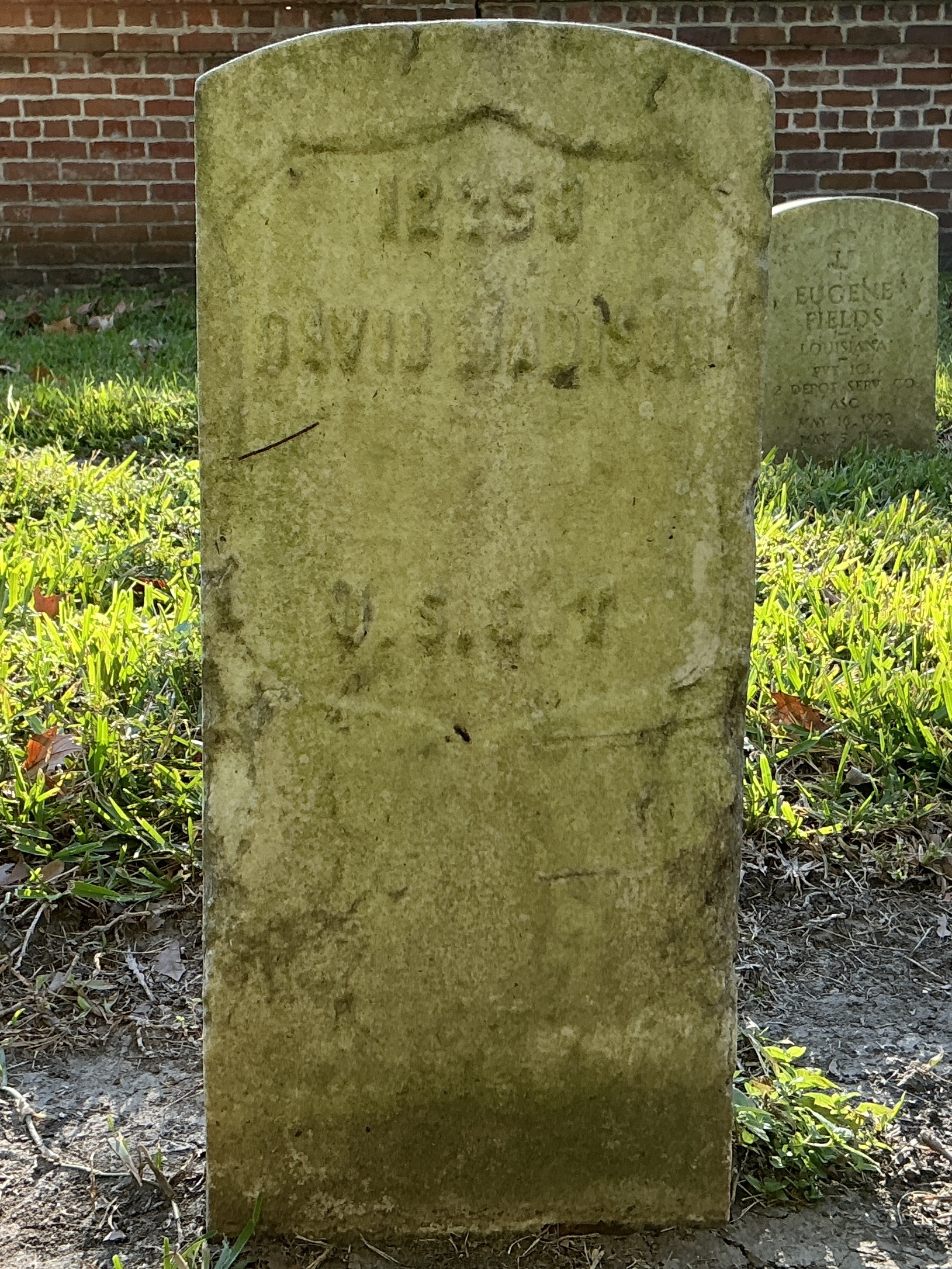 Front of historic upright marble headstone with recessed shield face.