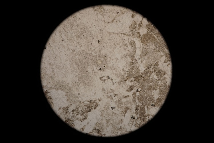 Circular microscopic image of rock structure.