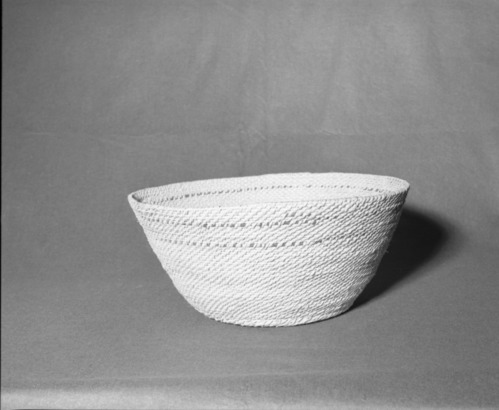 Mrs. Donald Segerstrom Collection. Object: Paiute basket. Dimensions: 19 x 8 1/2". Materials: willow, black cloth. Technology: interlocking stitch, fag ends tucked under, moving ends bound under, probably made for use as a laundry basket. Collection History: ---. Photographed of Michael Dixon, 1/83. Catalogued by Craig Bates and Barbara Beroza. Yosemite Collections, National Park Service.