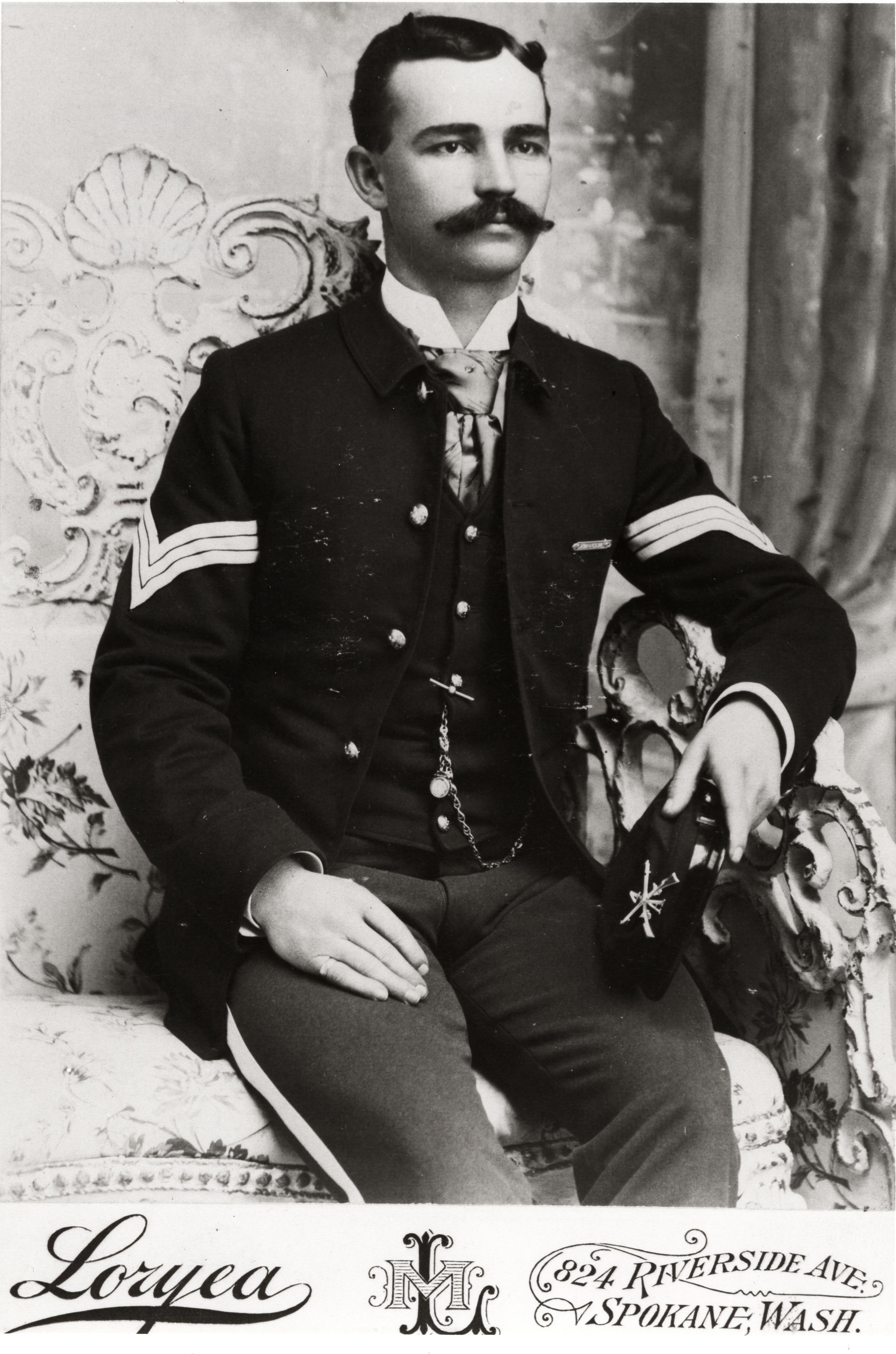 Black and white photograph of a man in a military uniform sitting for a photograph