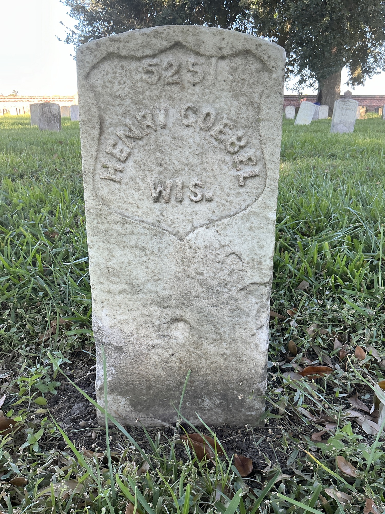 Front of historic upright marble headstone with recessed shield face.