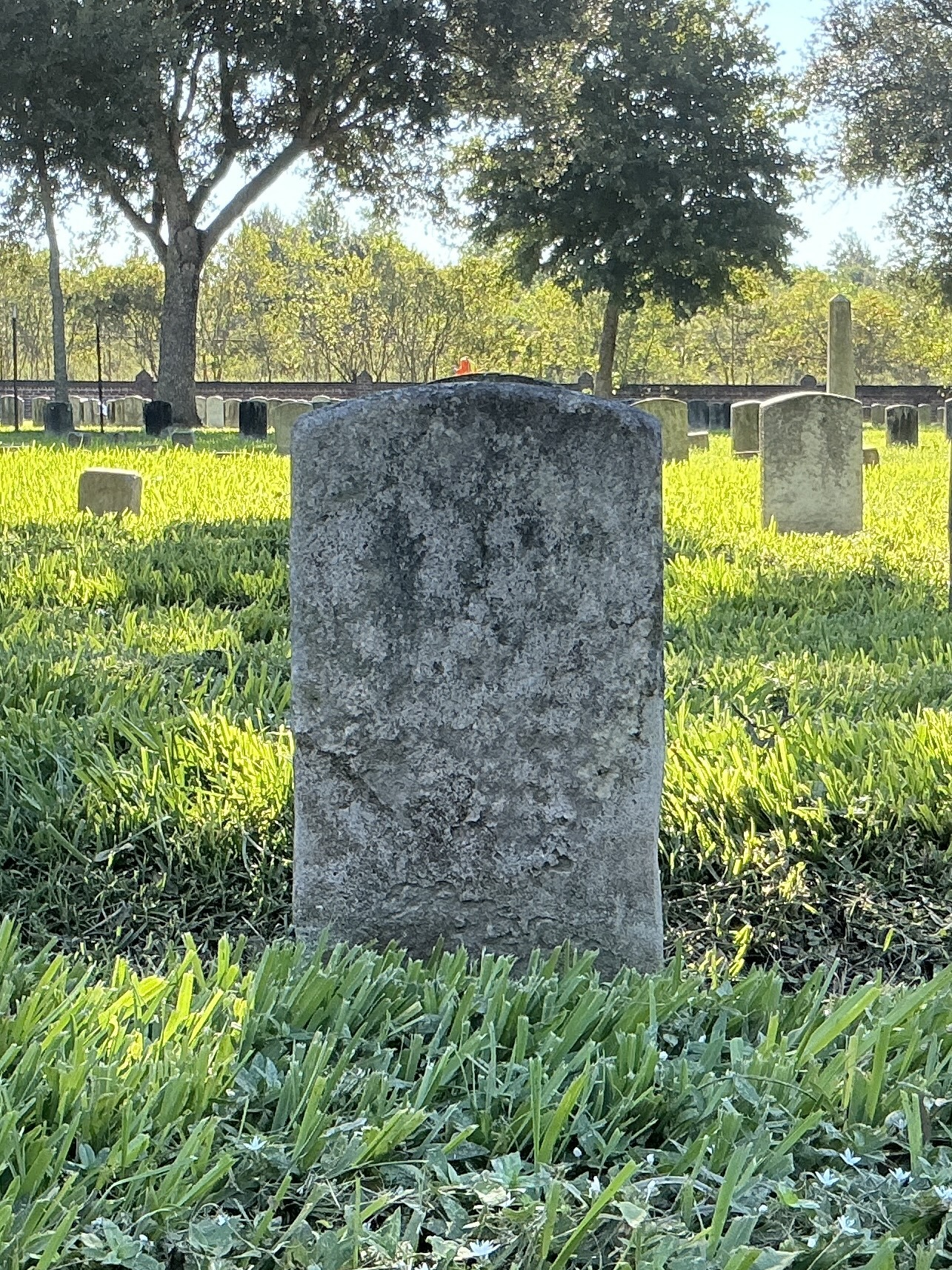 Back of historic upright marble headstone with recessed shield face.