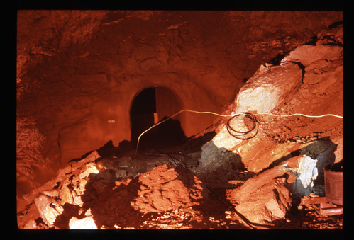 Rocky debris with arched tunnel in background
