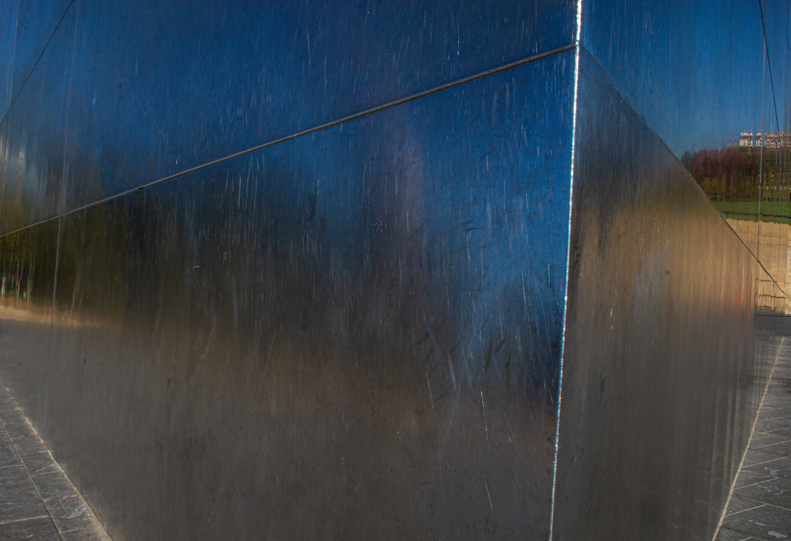 Shiny silver panel and welds on the Gateway Arch shot close-up so the blue sky is reflected in the steel.