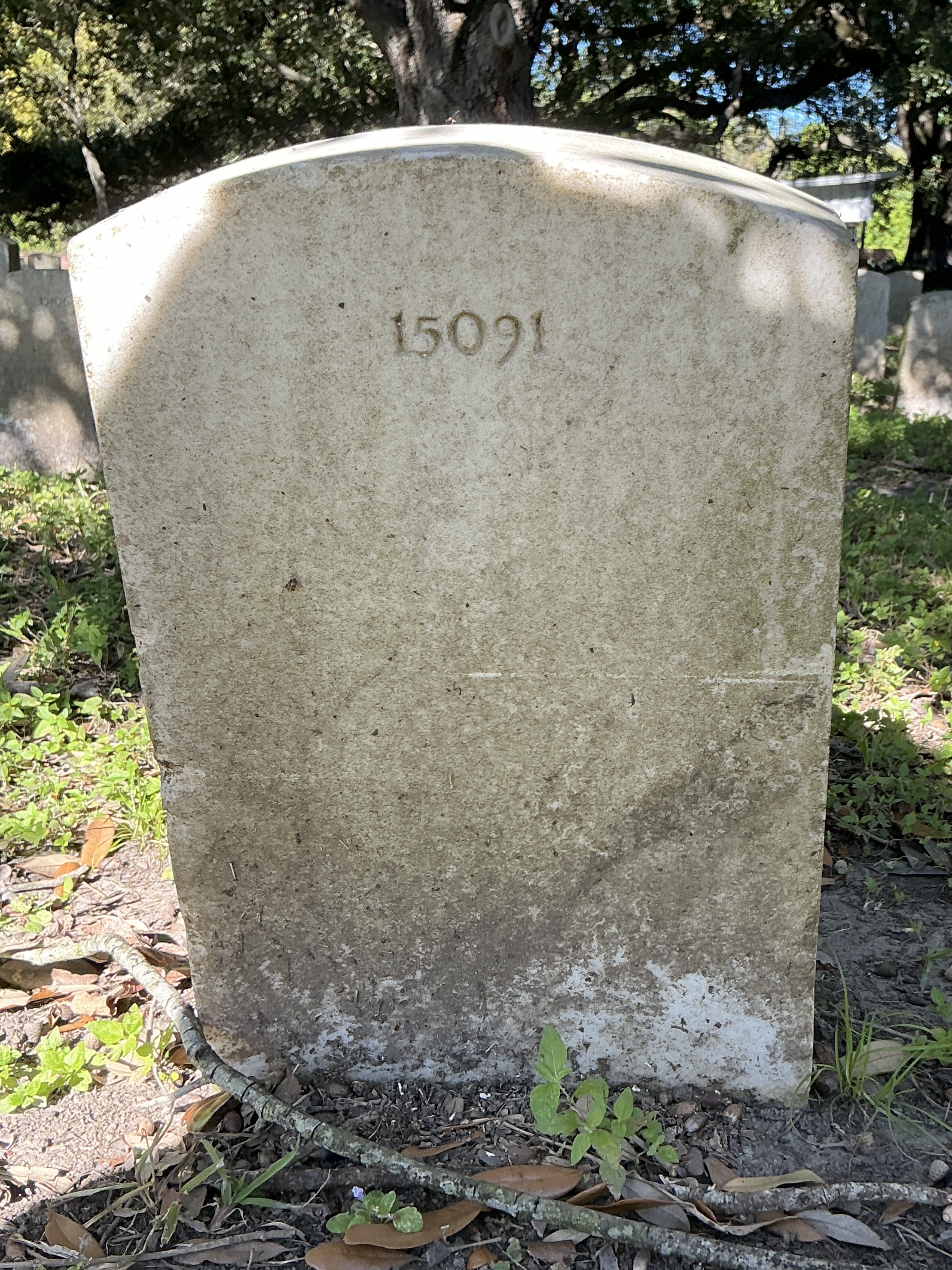 Back of upright marble headstone with flat face.