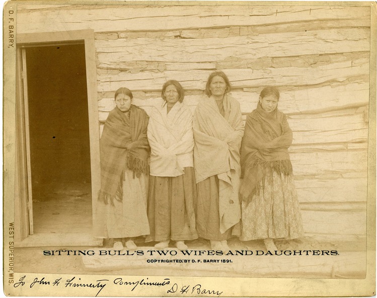Four Women, Sitting Bull's Wives and Daughters, in Front of a Log Building