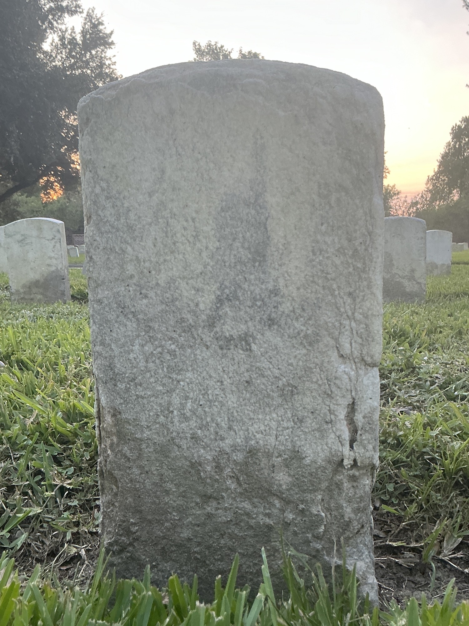 Back of historic upright marble headstone with recessed shield face.
