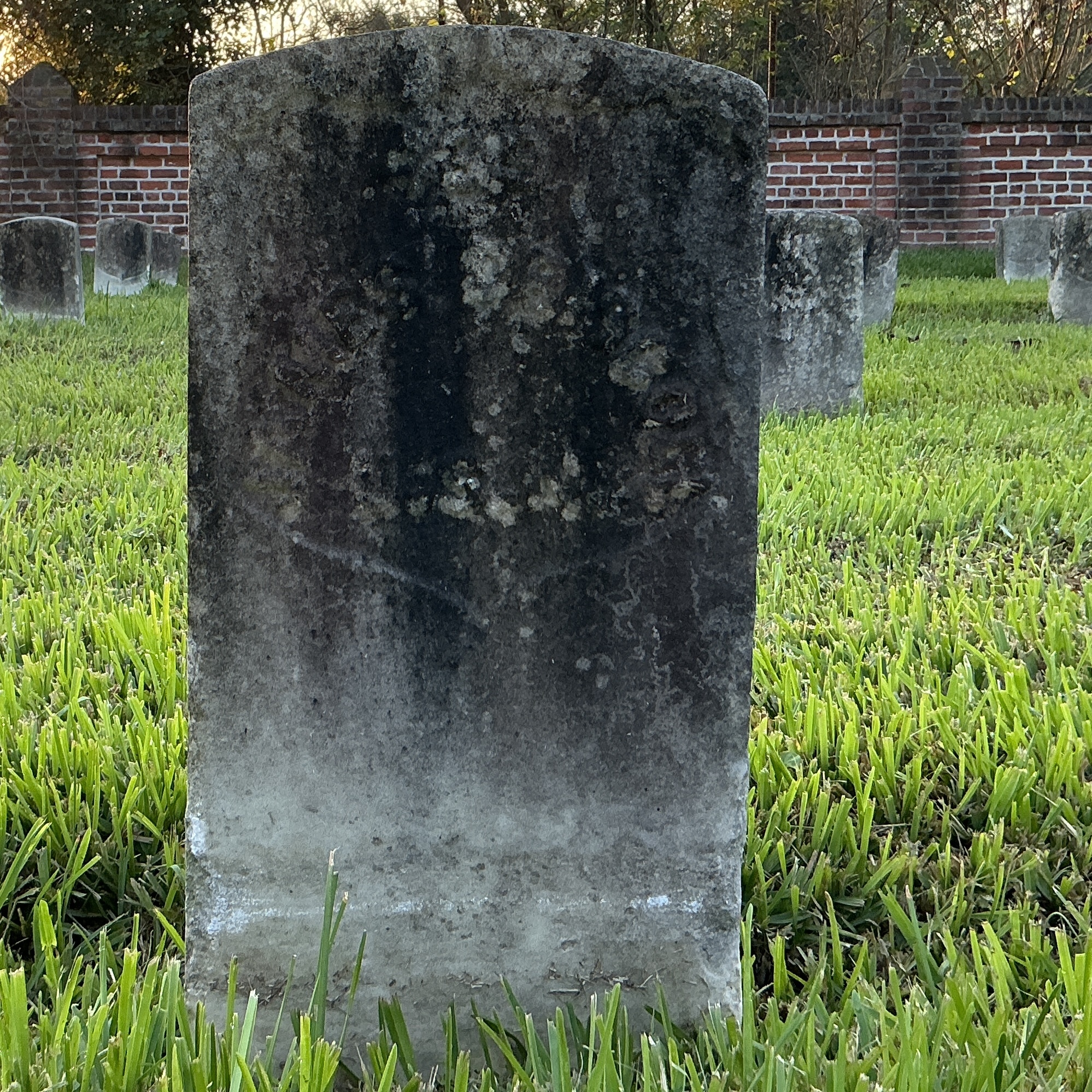 Front of historic upright marble headstone with recessed shield face.