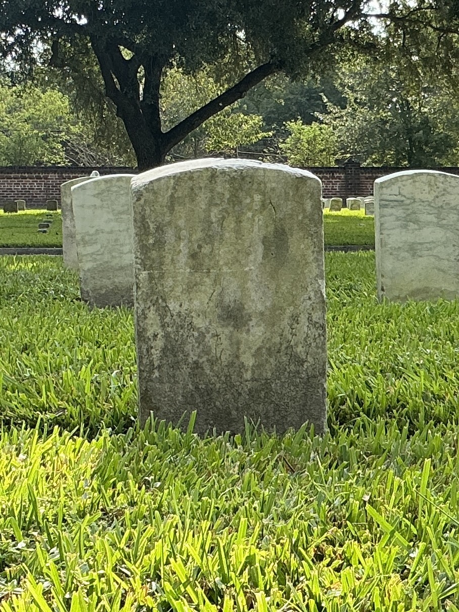 Back of historic upright marble headstone with recessed shield face.
