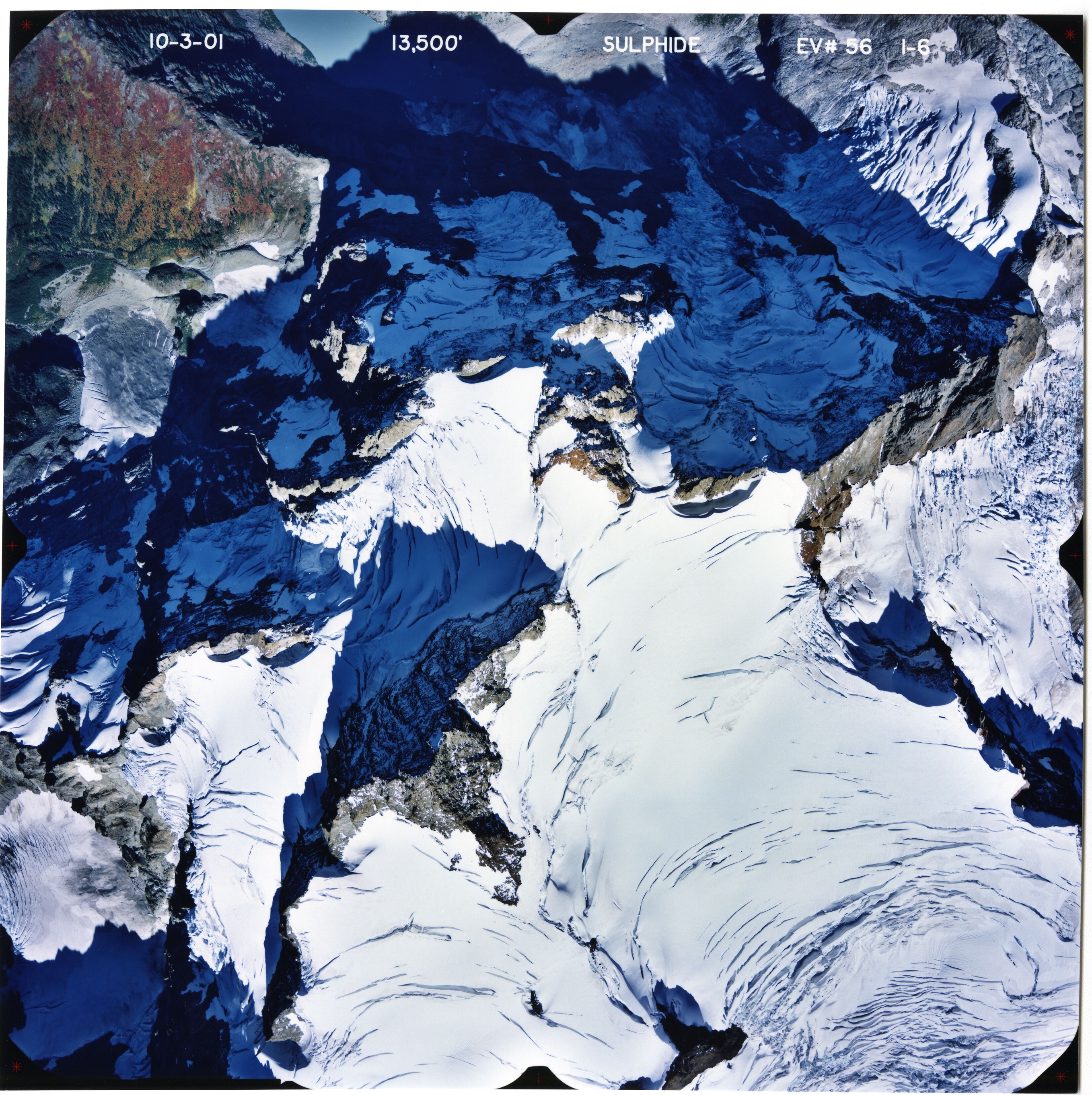 Color aerial photograph of glacier on mountain peak.
