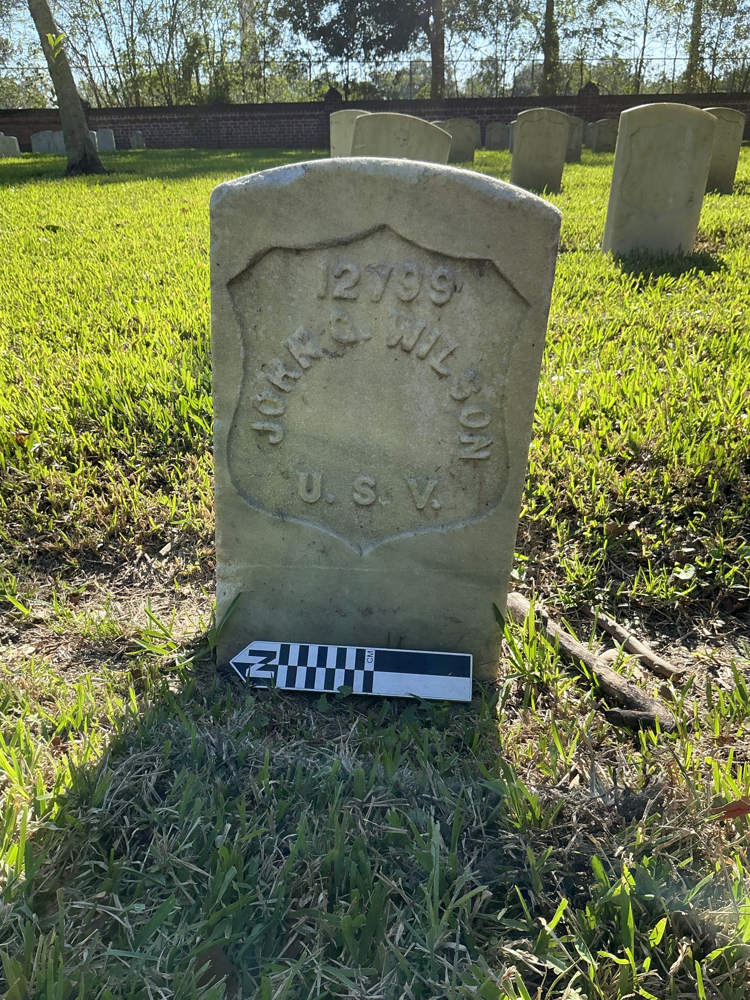 Back of historic upright marble headstone with recessed shield face.