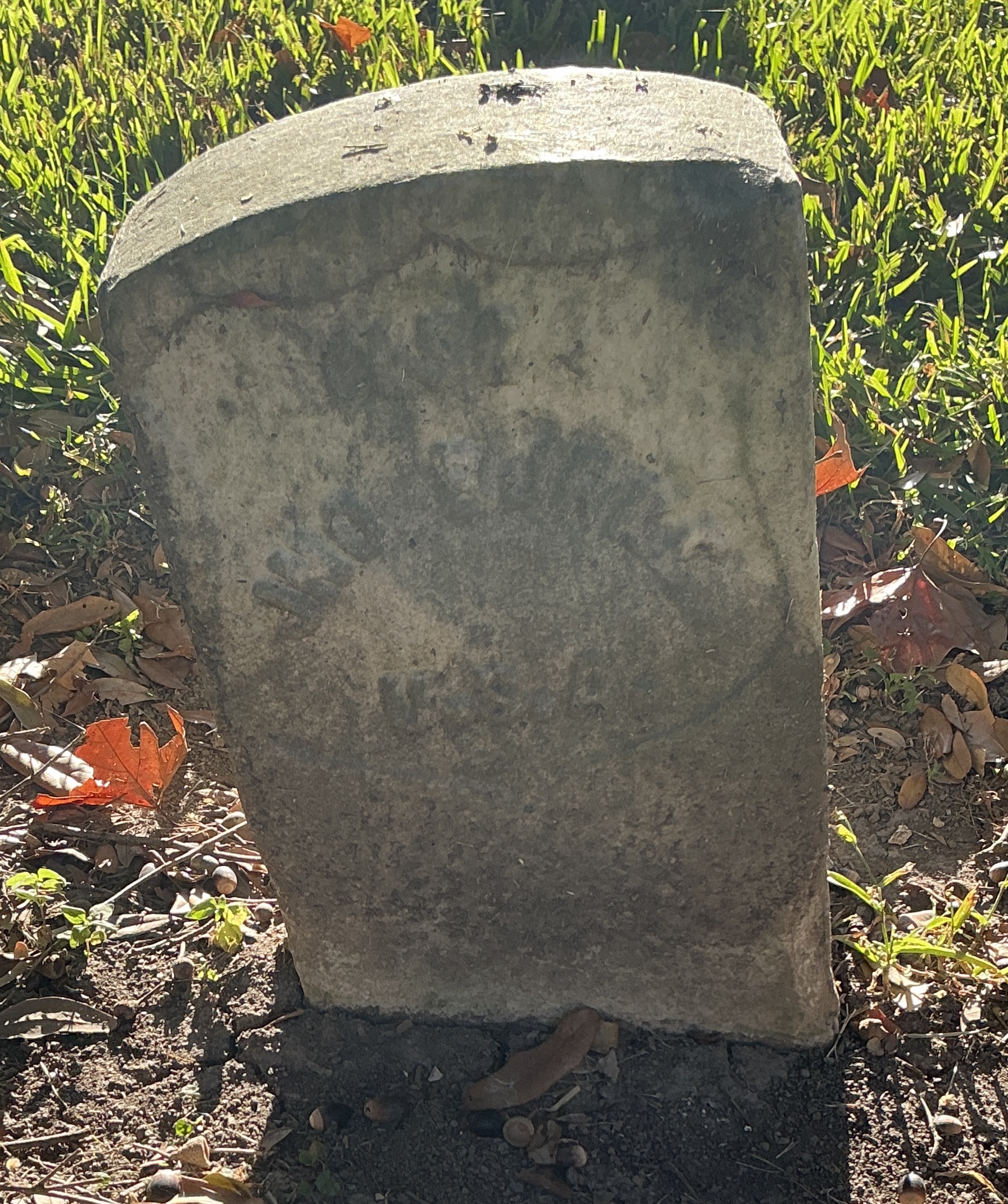 Front of historic upright marble headstone with recessed shield face.