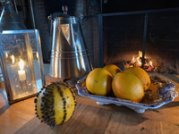 Oranges on a counter, one has cloves inserted into it.