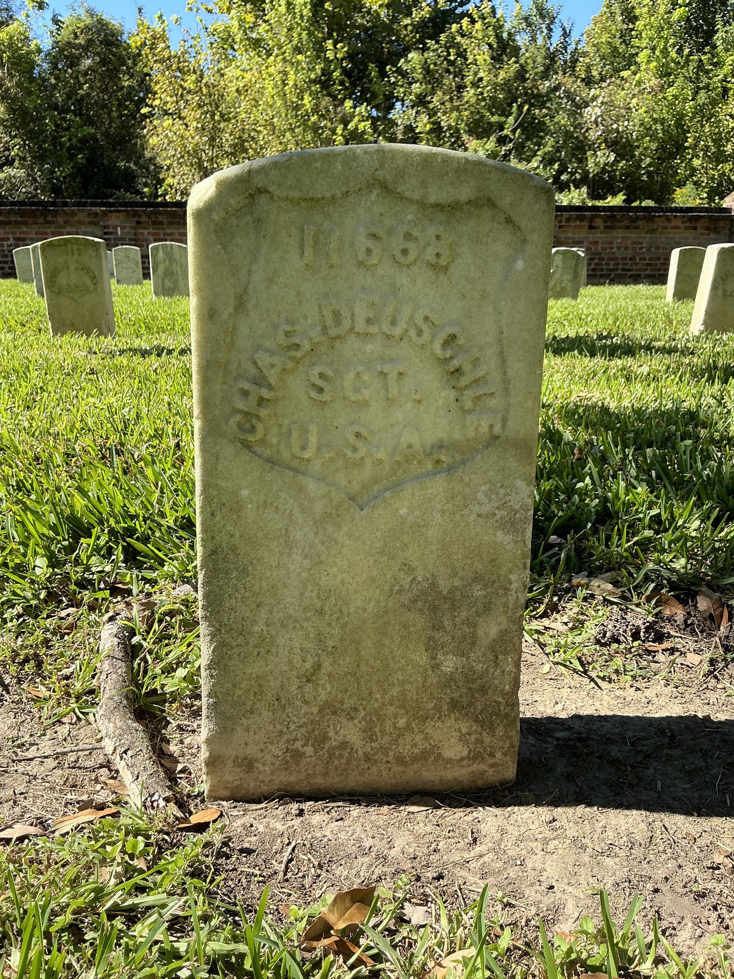 Front of historic upright marble headstone with recessed shield face.