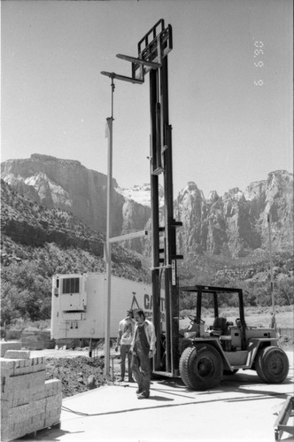 Workers operating a life machine during construction of headquarters addition.