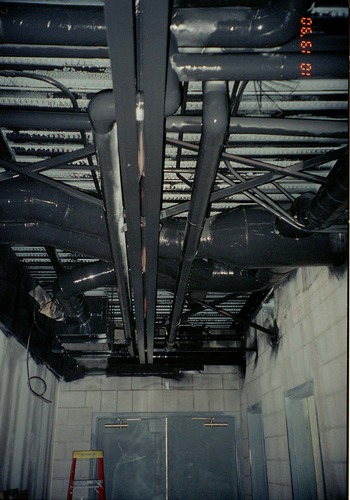 Park Headquarters Renovation: overhead pipes and exterior doors in northwest hallway, lower level.