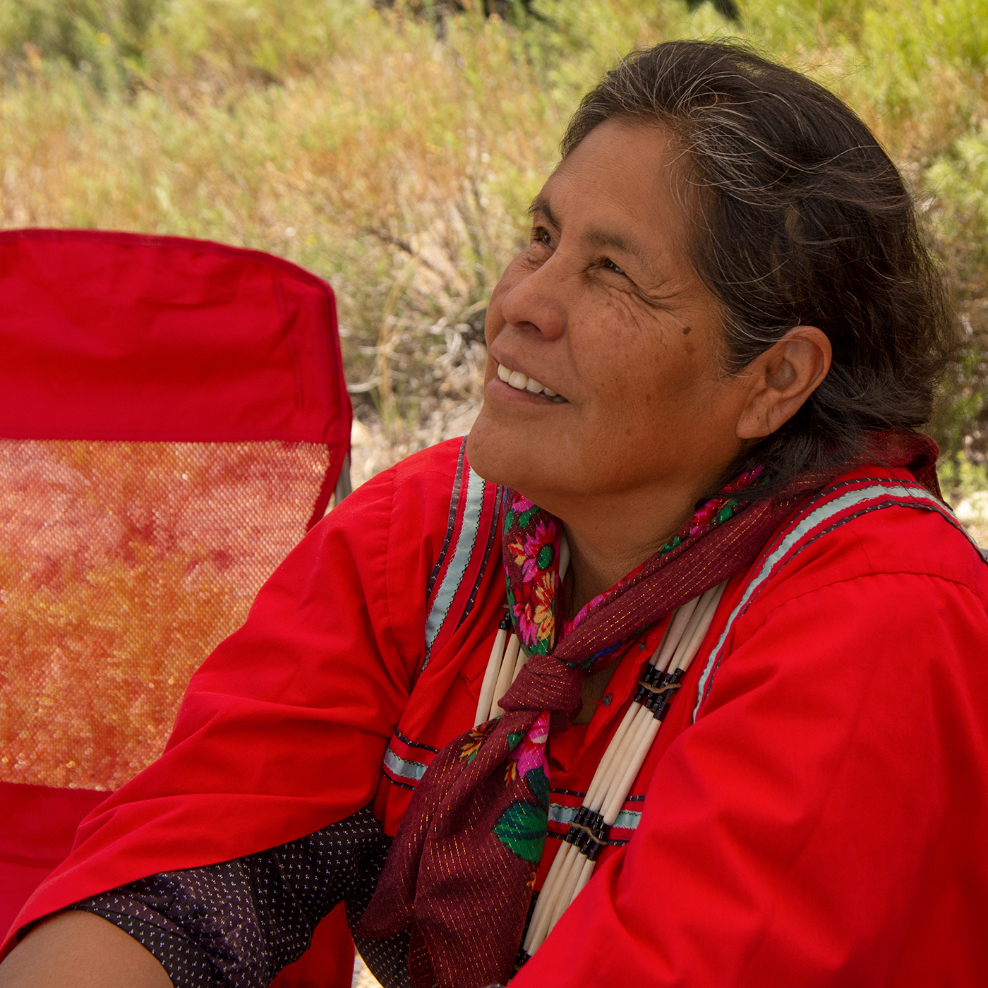 A Jicarilla Apache woman in colorful regalia tells traditional stories.