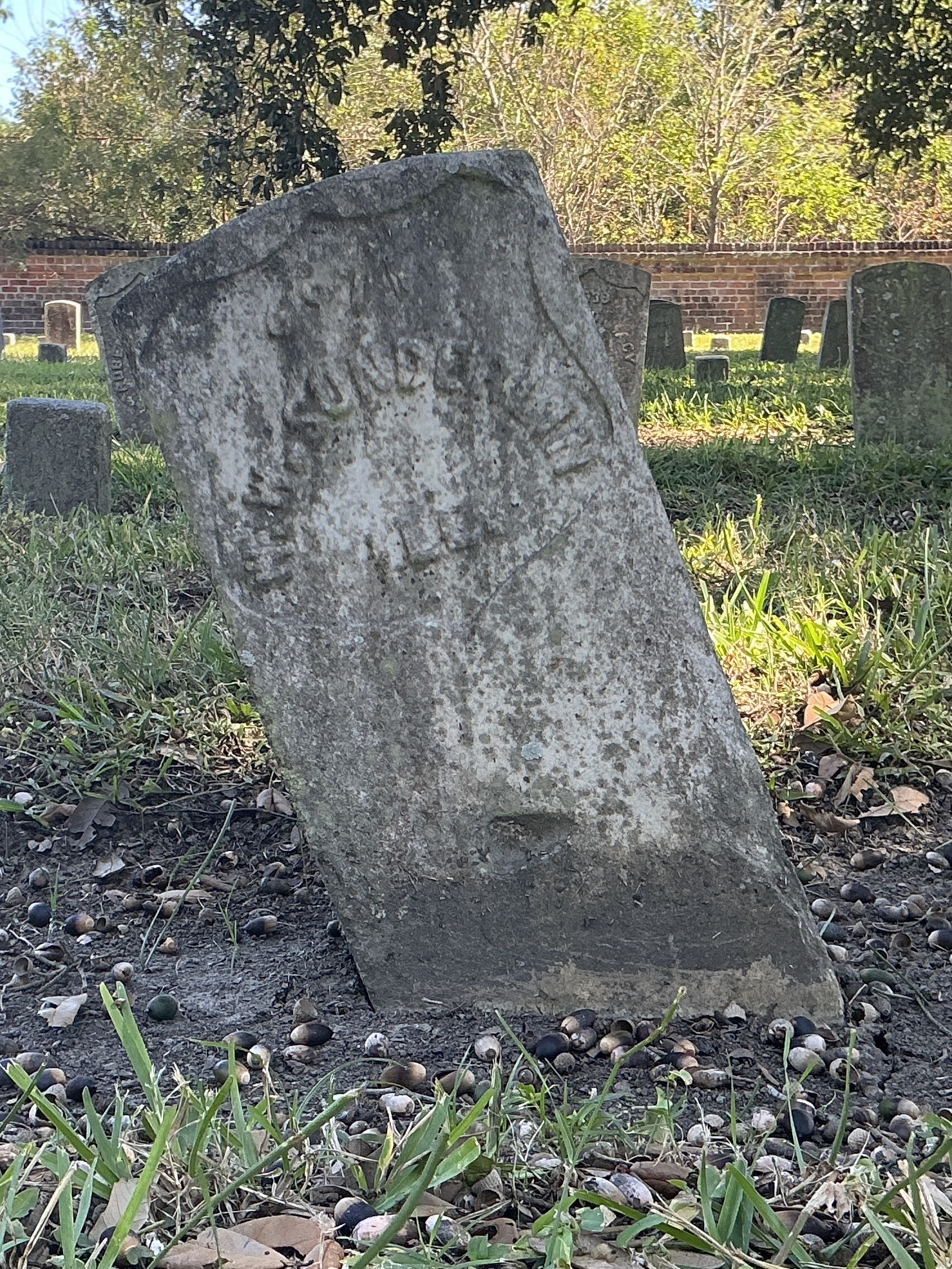 Front of historic upright marble headstone with recessed shield face.