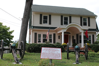 Two cannon pointed at a two story house