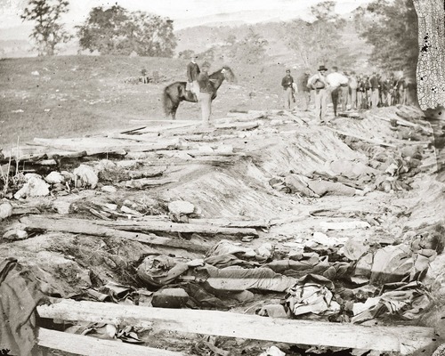 Confederate dead at Bloody Lane, looking northeast from the south bank. The group of Union soldiers looking on were likely members of the 130th Pennsylvania, who were assigned burial detail on the 19th.