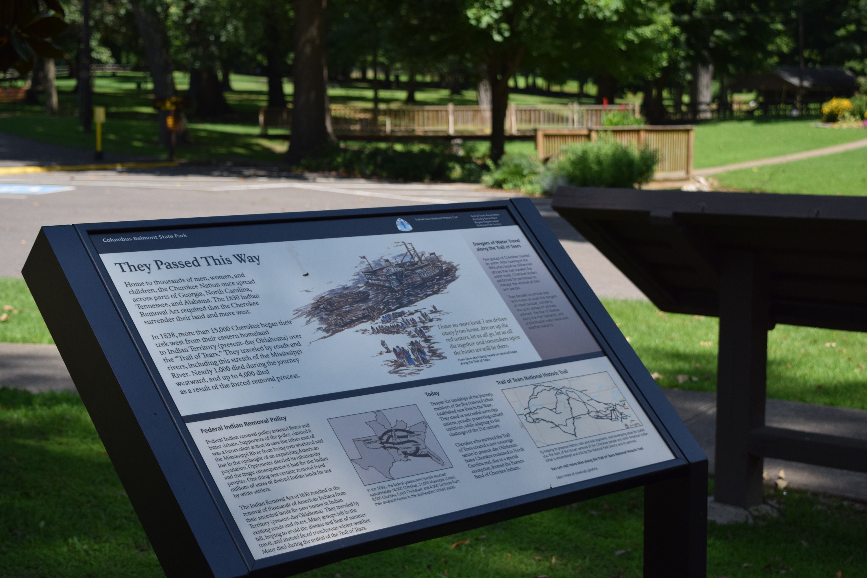 
An outdoor display with text and maps in a park setting.