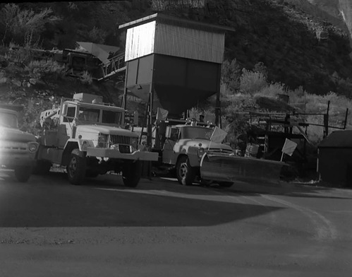 Dry sand hopper at Oak Creek Maintenance utility area - Incentive Award suggestion. Trucks, plow, and equipment in foreground.