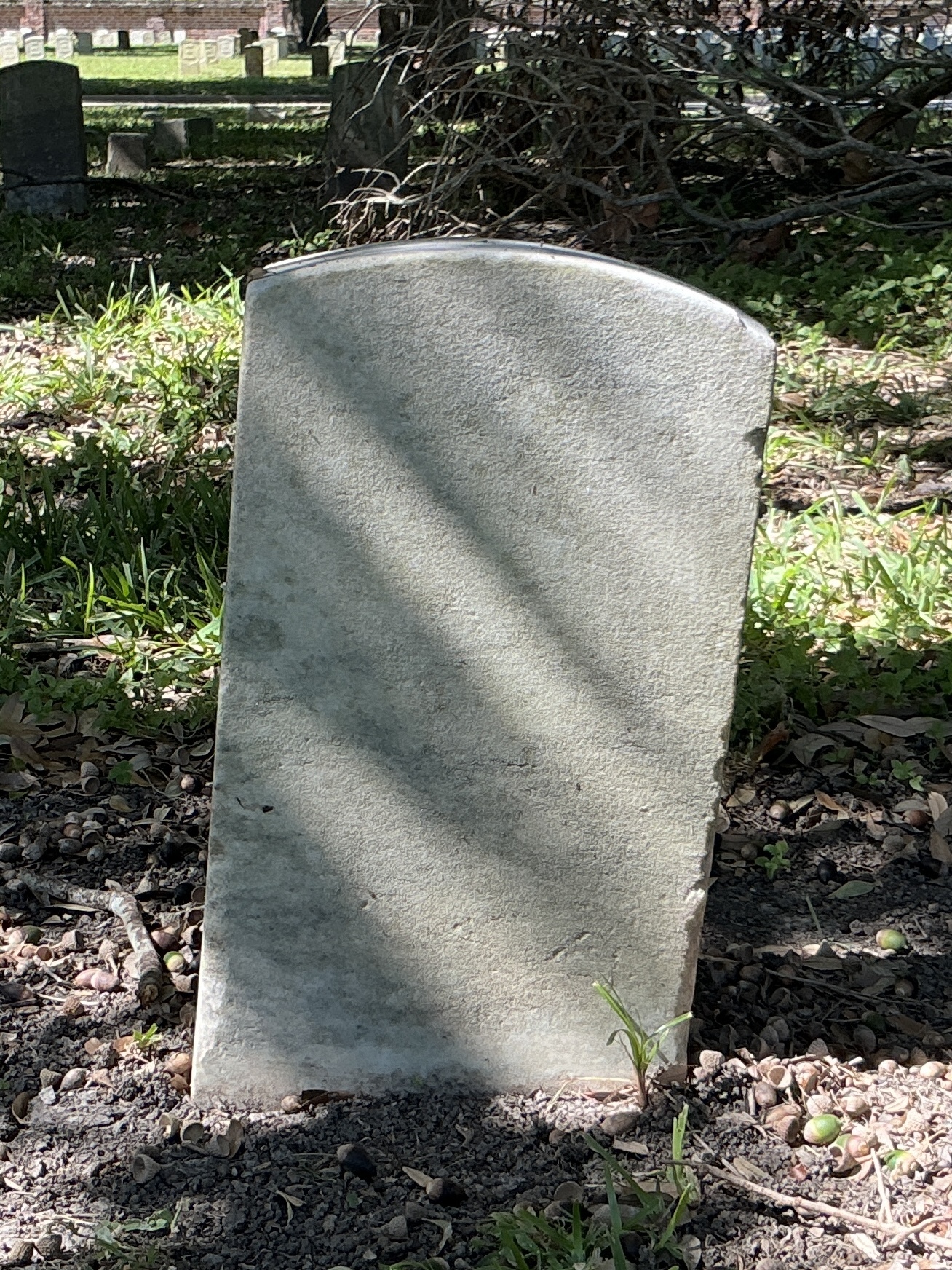 Back of historic upright marble headstone with recessed shield with recessed lettering face.