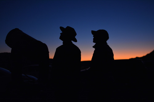two silhouetted rangers and a telescope